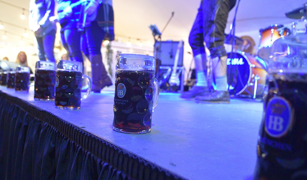 Steins of beer line the stage at the Great Northwest Oktoberfest as contestant prepare for the stein-holding competition. (Heidi Desch/Whitefish Pilot)