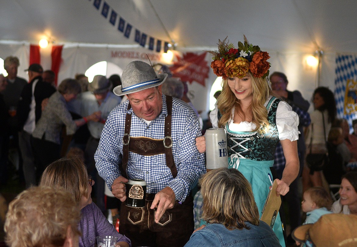 Tony Veseth and Hop Queen Kate Houlihan chat up the crowd Thursday night at the Great Northwest Oktoberfest looking for competitors for one of the many competitions held during the evening. (Heidi Desch/Whitefish Pilot)