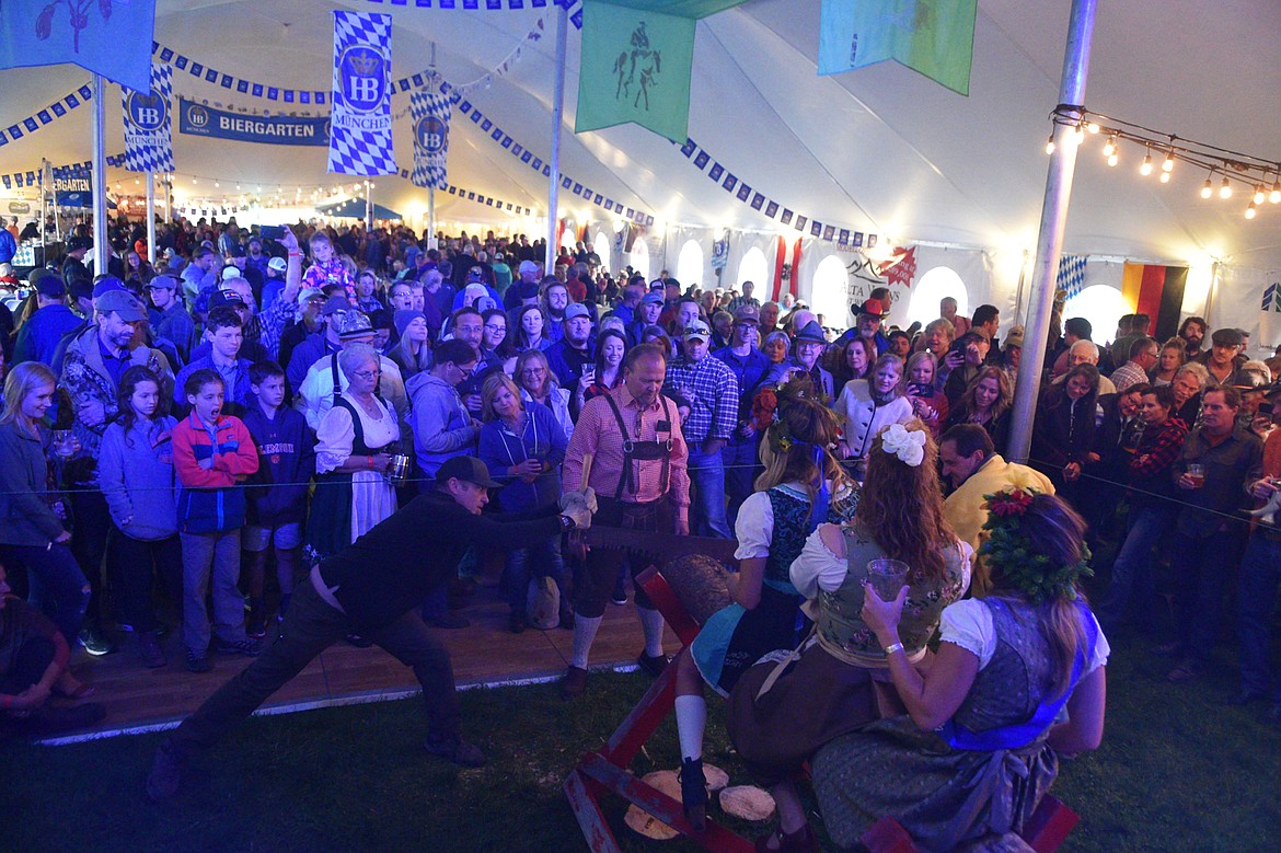 The crowd gathers around to watch competitors in the men&#146;s log-sawing competition at the stage at the Great Northwest Oktoberfest. (Heidi Desch/Whitefish Pilot)