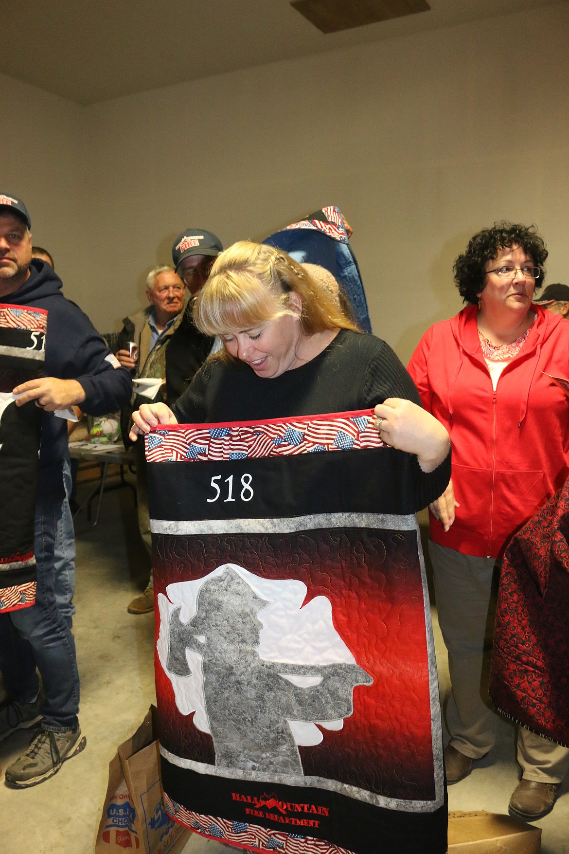 Photo by MANDI BATEMAN
Hall Mountain Firefighter and EMT, Sandy Steinhagen, admires her personalized quilt.