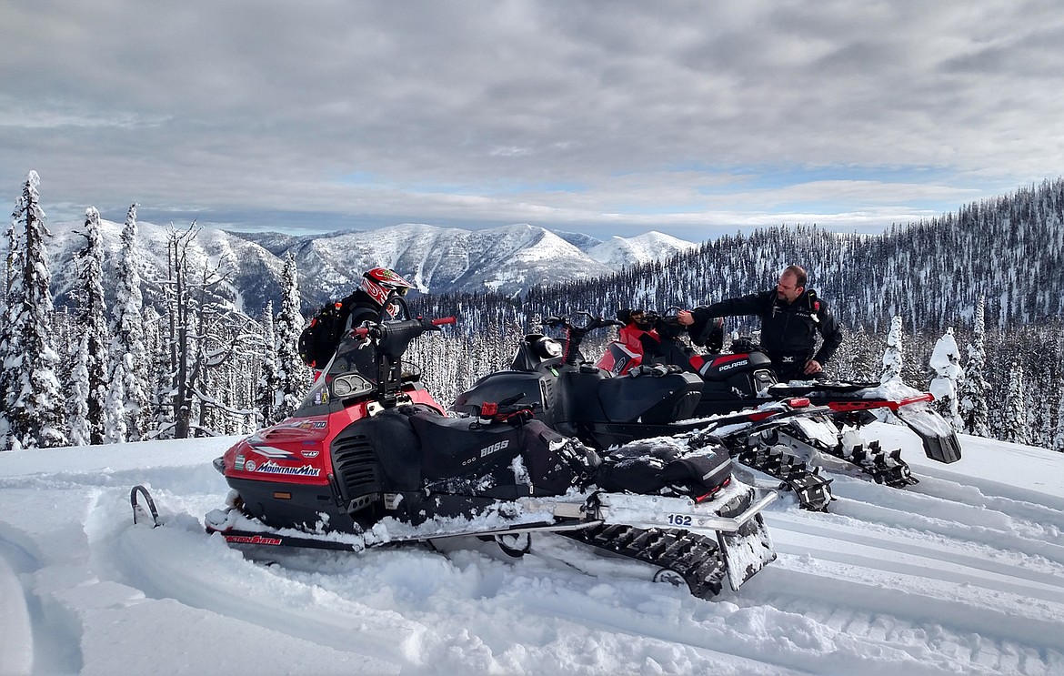 Snowmobilers pause for a break while riding in the Stillwater State Forest. (Photo courtesy Dave Colvill)