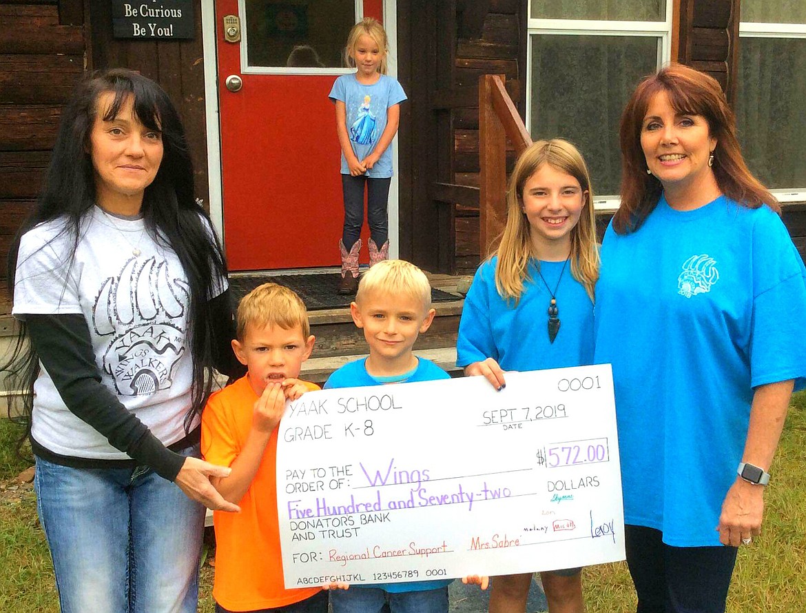 THE YAAK Wings Walk was held Sept. 7 to benefit regional cancer support, according to event organizer Roberta Deneau. The Yaak School children and their teacher, Sabr&eacute; Burson-Alderete, presented a bigger than life check in the amount of $572 to the Yaak Wings Walkers. Pictured are Burson-Alderete, Deneau, first-grade students Leroy Lambert and Micah Lawson, fourth grader Shyanne Manly, and kindergartener Melany Allen. Third grader Zon Johnson was not pictured.