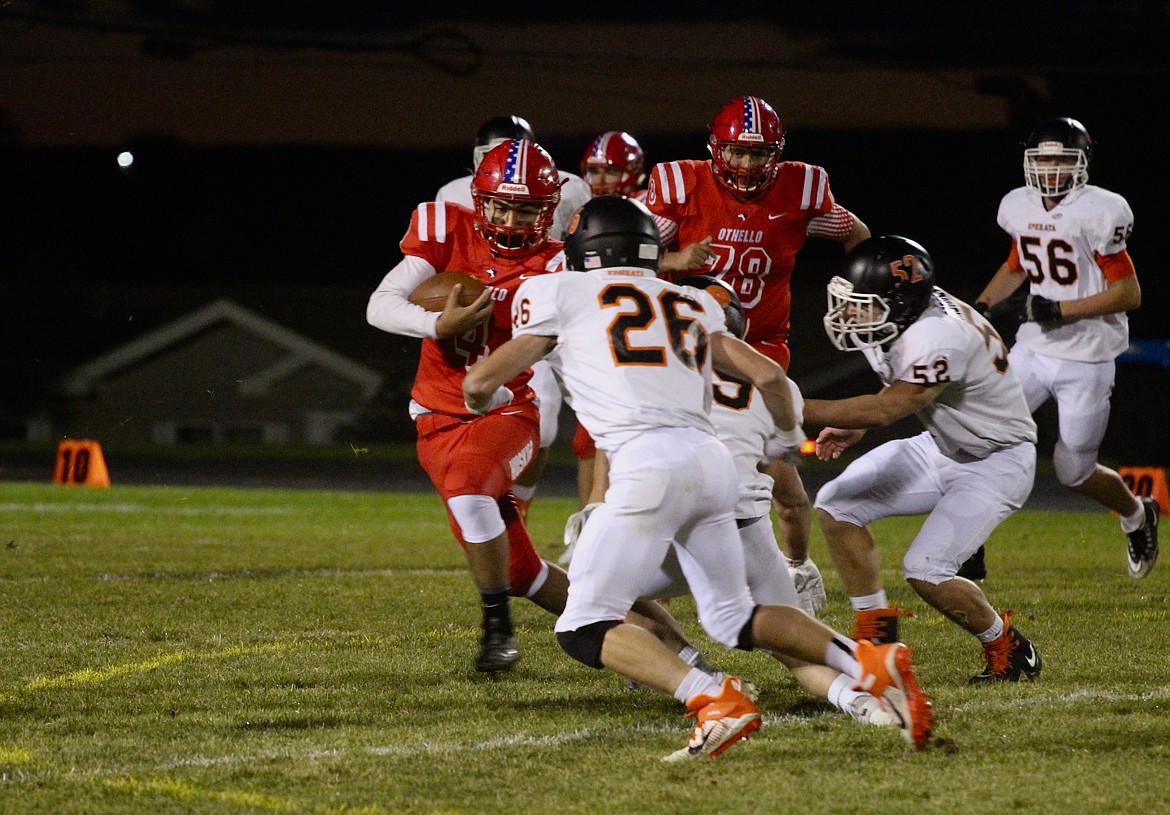 Casey McCarthy/Columbia Basin Herald Othello back Isaac Barragan makes the cut outside as the Ephrata defense closes in on Friday night at Othello High School