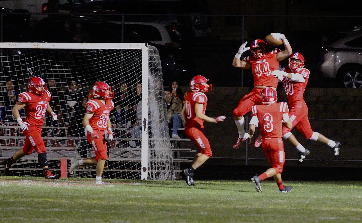 Casey McCarthy/Columbia Basin Herald Othello's Isaiah Perez celebrates with his teammates in the endzone after taking the interception in for the touchdown to open up the lead for the Huskies in the first quarter.