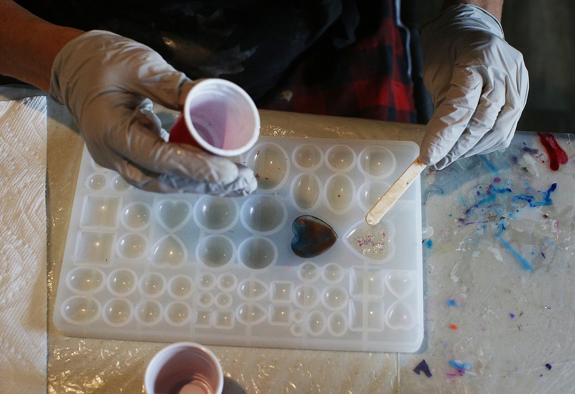 Artist Twyla Jensen carefully drips resin mixed with ashes from a loved one into a heart mold. It takes her about an hour to create a jewelry piece and cures overnight.  (LOREN BENOIT/Press)