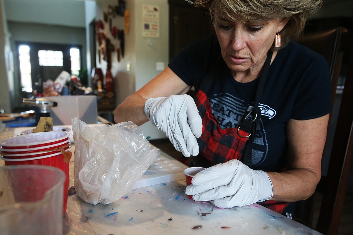 Artist Twyla Jensen sprinkles some of her father&#146;s ashes into a cup filled with resin before pouring them into a heart mold. (LOREN BENOIT/Press)