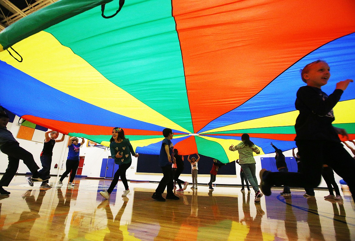 Students at Winton Elementary play with a parachute during P.E. in the school's gym Wednesday morning. P.E. teacher Lisa Blattstein was recently awarded a grant though the Excel Foundation to install a climbing wall in Winton's gym. The wall should be up by the end of December. (LOREN BENOIT/Press)