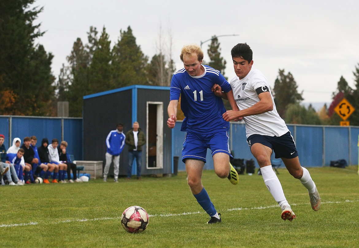 Coeur d'Alene's Nathan Durocher dribbles the ball near Lake City's goal while defended by Jackson Henkle during the 5A Region 1 Championship game Thursday at Coeur d'Alene High. (LOREN BENOIT/Press)