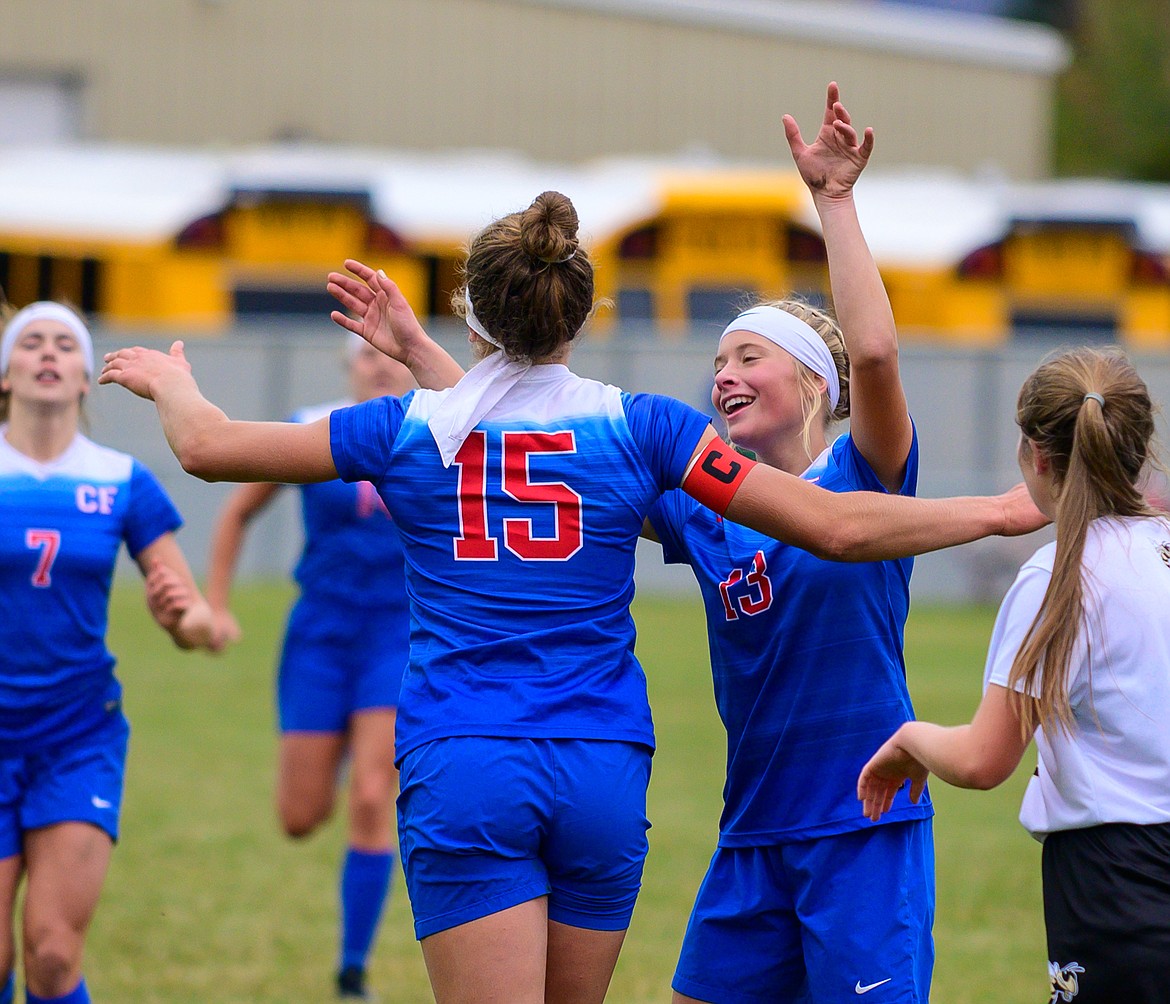 Josie Windauer (15) is congratulated by teammate Sydney Mann (13) after Windauer scored a goal in the first half against Stevensville in the girls class A soccer playoffs Saturday in Columbia Falls. (Chris Peterson photo)