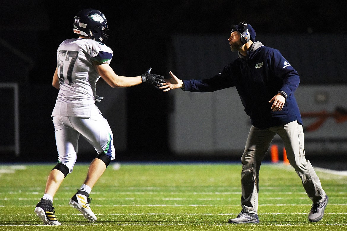 Glacier head coach Grady Bennett congratulates defensive lineman Henry Nuce (57) in the second half against Flathead during a crosstown matchup at Legends Stadium on Friday. (Casey Kreider/Daily Inter Lake)