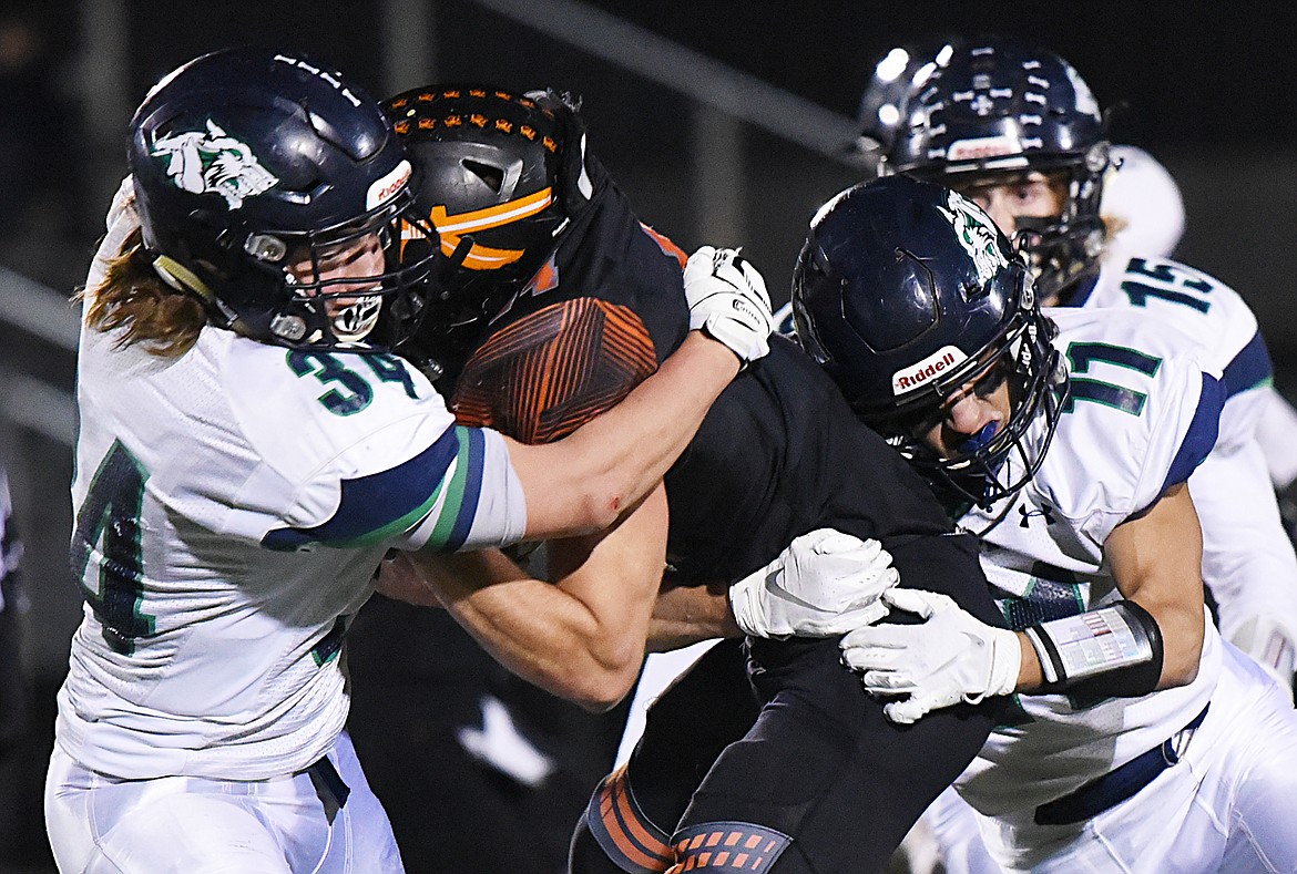 Glacier defenders Alec Thomas (34) and Gator Mostek (11) wrap up Flathead running back Tanner Russell (44) on a run in the second quarter during a crosstown matchup at Legends Stadium on Friday. (Casey Kreider/Daily Inter Lake)