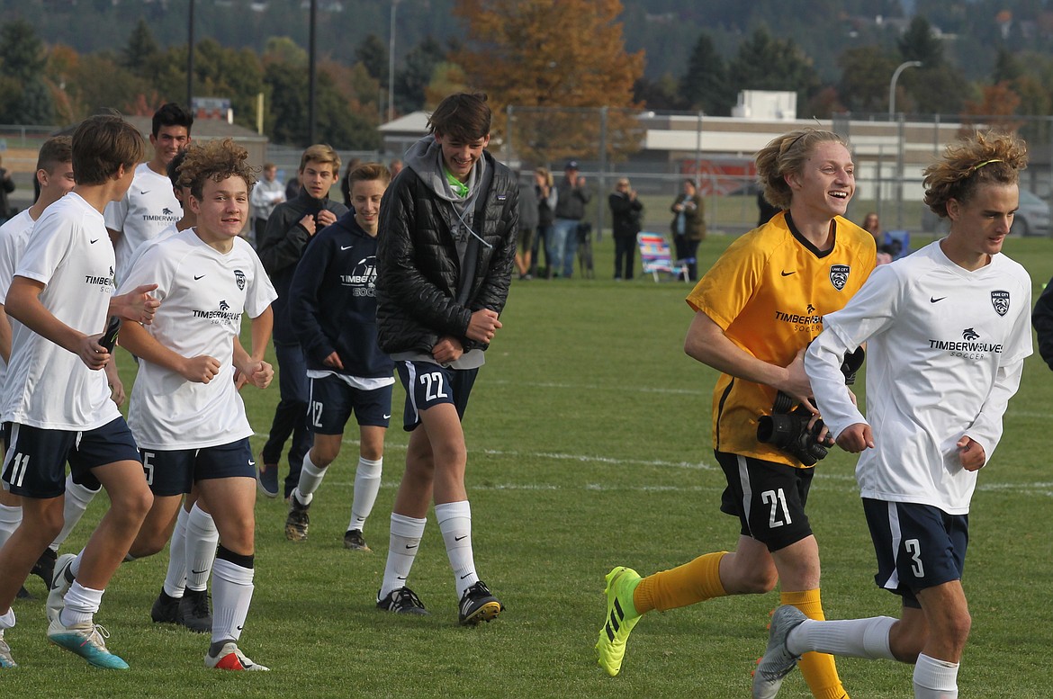 Members of the Lake City boys soccer team run back to the bench after greeting fans following a 4-1 win over Post Falls. The win qualified Lake City for state.
JASON ELLIOTT/Press