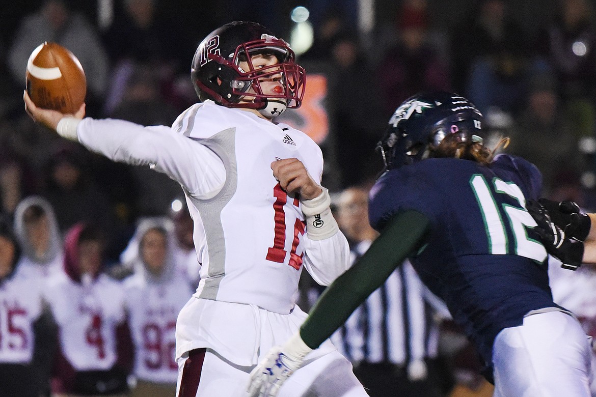 Helena quarterback Kaden Huot (12) throws under pressure from Glacier&#146;s Rogun Nicholson (12) in the second half at Legends Stadium on Friday. (Casey Kreider/Daily Inter Lake)