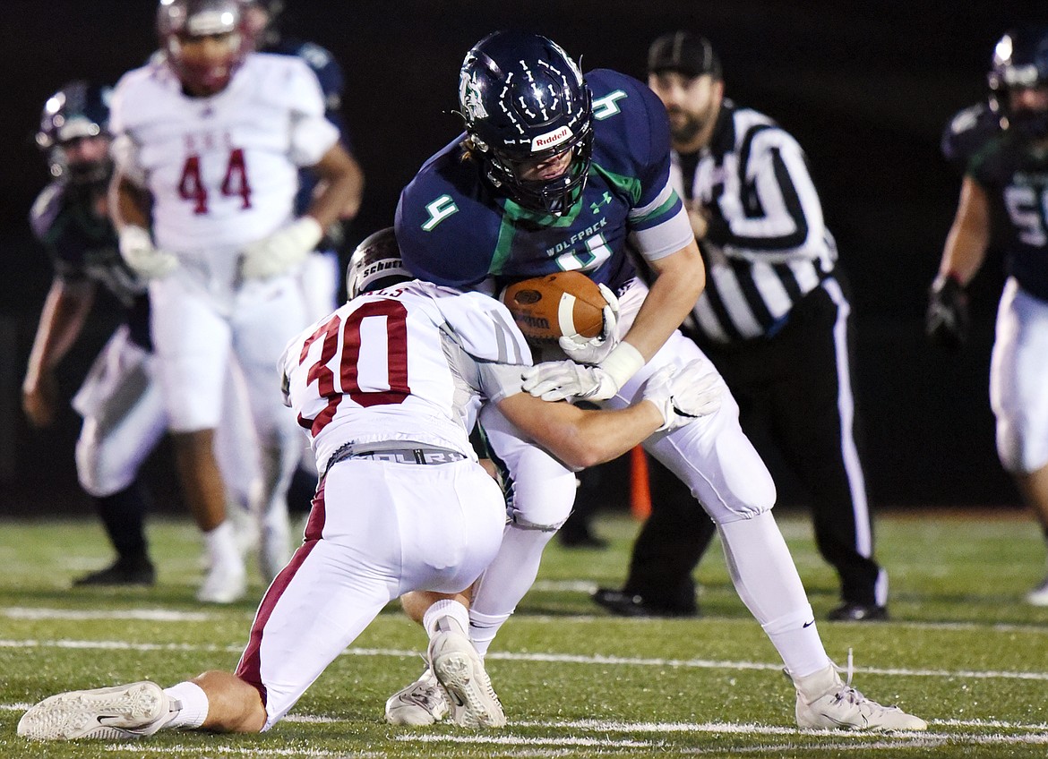 Glacier wide receiver Luke Bilau (4) is tackled by Helena defensive back Connor Rigsby (30) after a second quarter reception at Legends Stadium on Friday. (Casey Kreider/Daily Inter Lake)