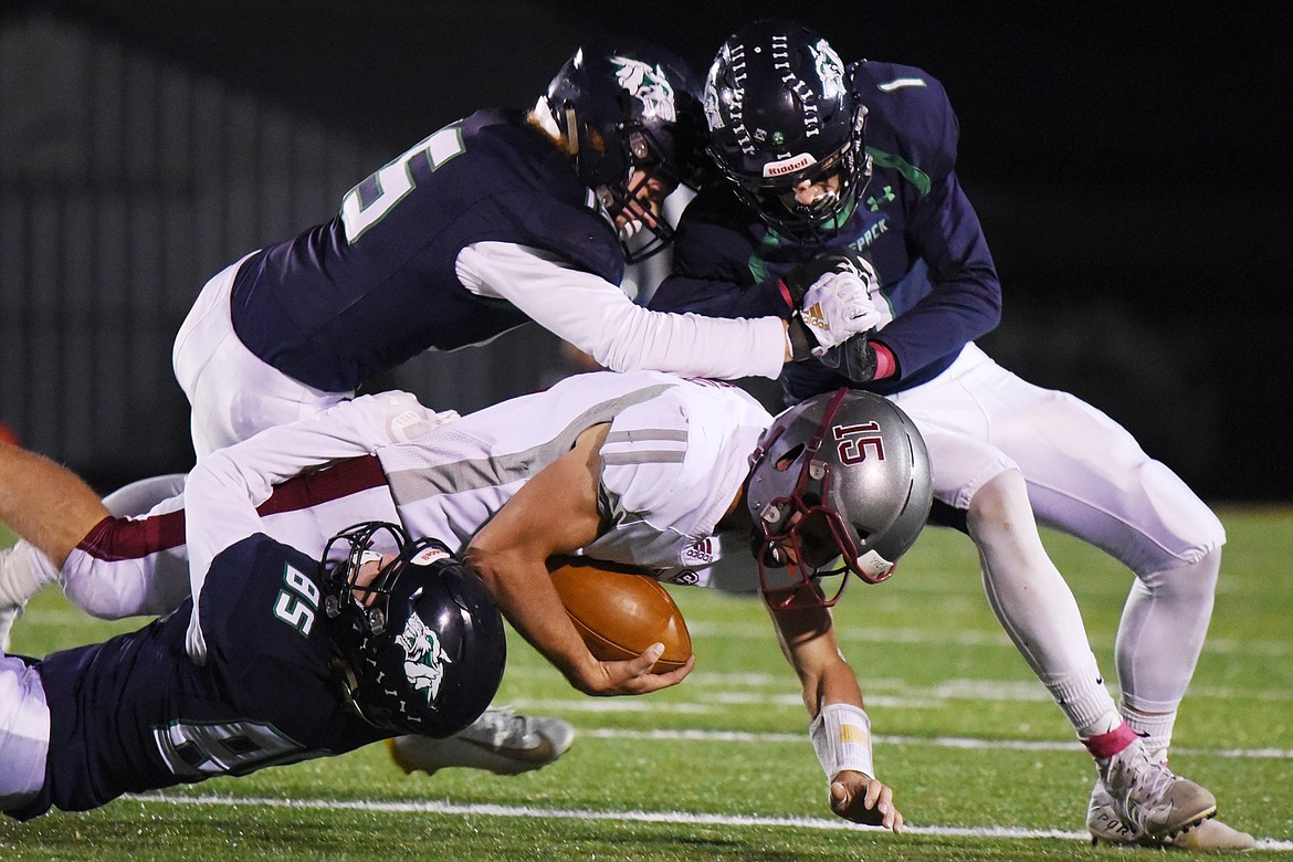 Glacier&#146;s Mason Naomi (85), Hunter Karlstad (15) and Colin Bowden (1) bring down Helena&#146;s Hayden Ferguson after a reception at Legends Stadium on Friday. (Casey Kreider/Daily Inter Lake)