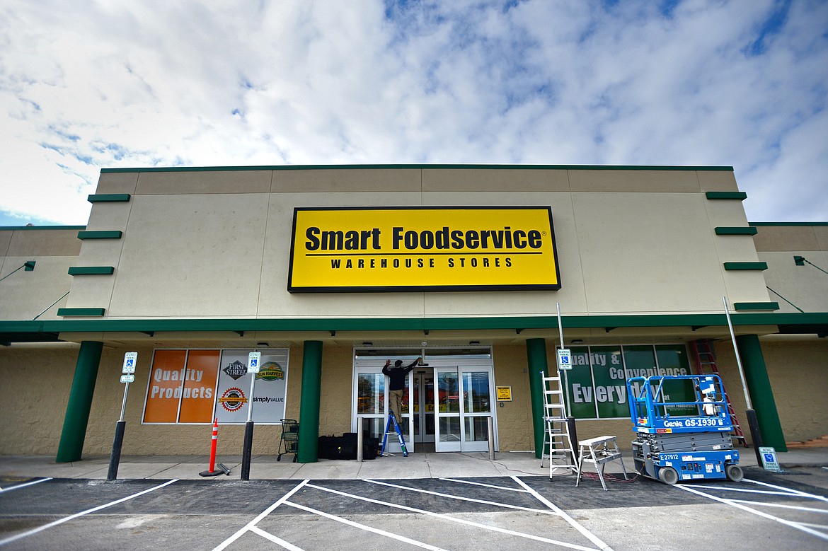 A worker puts the finishing touches on the exterior of Smart Foodservice at 1031 E. Highway 2 in Kalispell on Thursday, Oct. 10. (Casey Kreider/Daily Inter Lake)