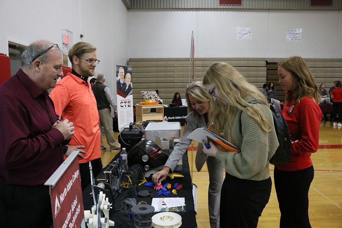 (Photo by MARY MALONE)
Idaho&#146;s superintendent of public instruction Sherri Ybarra, center, paid a visit to Sandpoint High School on Friday where she got to see some of the different programs represented at the North Idaho College CTE Roadshow, including the computer-aided design program, which had 3D printed designs such as the pink octopus she is reaching for in the photo.