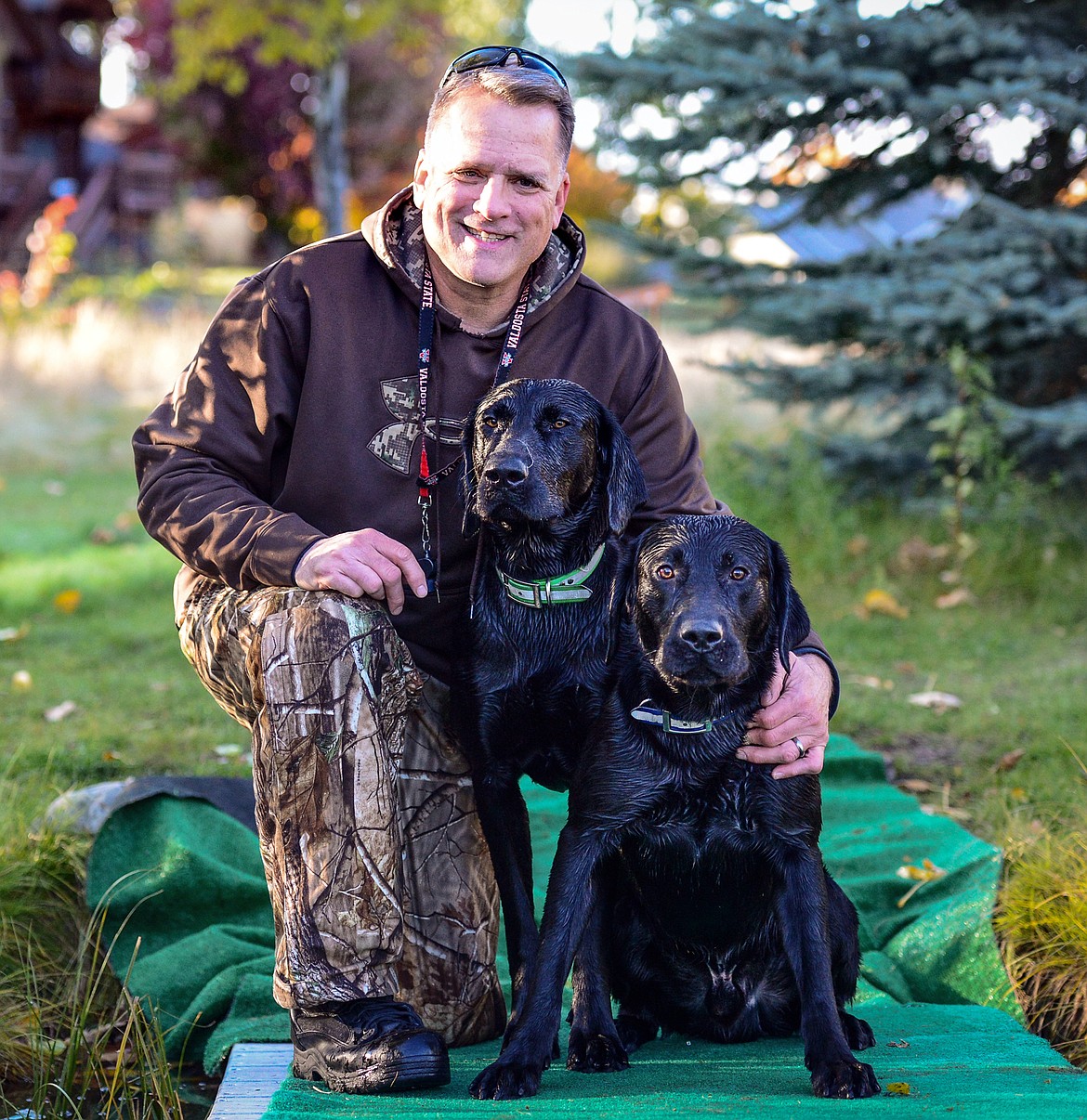 Bill Helfer with 18-month-old black Labs, Trooper, left, and Charger, during a DockDogs practice session in the Lower Valley on Thursday, Oct. 10. (Casey Kreider/Daily Inter Lake)