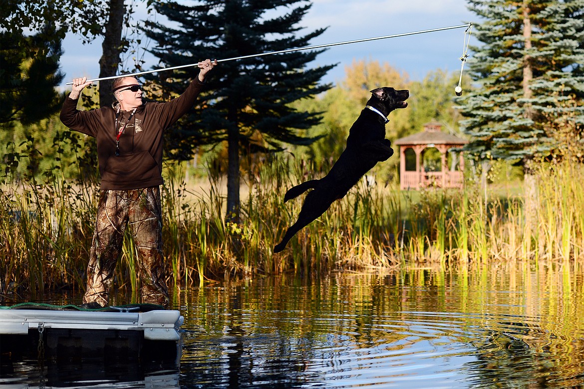 Bill Helfer and Charger, an 18-month-old black Lab, train for the DockDogs Extreme Vertical event during a practice session in the Lower Valley on Thursday, Oct. 10. (Casey Kreider/Daily Inter Lake)