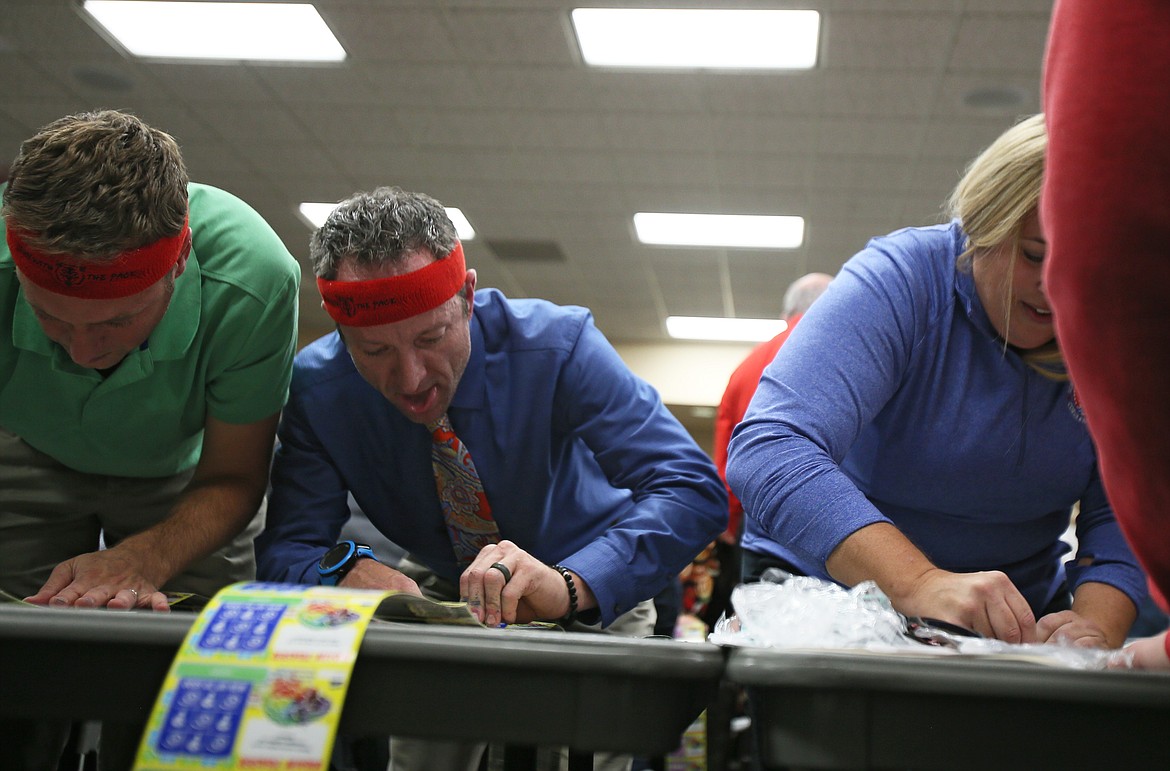 DEVIN WEEKS/Press
Farmin Stidwell Elementary School Principal Erik Olson, center, races through a stack of scratch tickets at Idaho Lottery&#146;s Scratch for Schools event Wednesday evening.