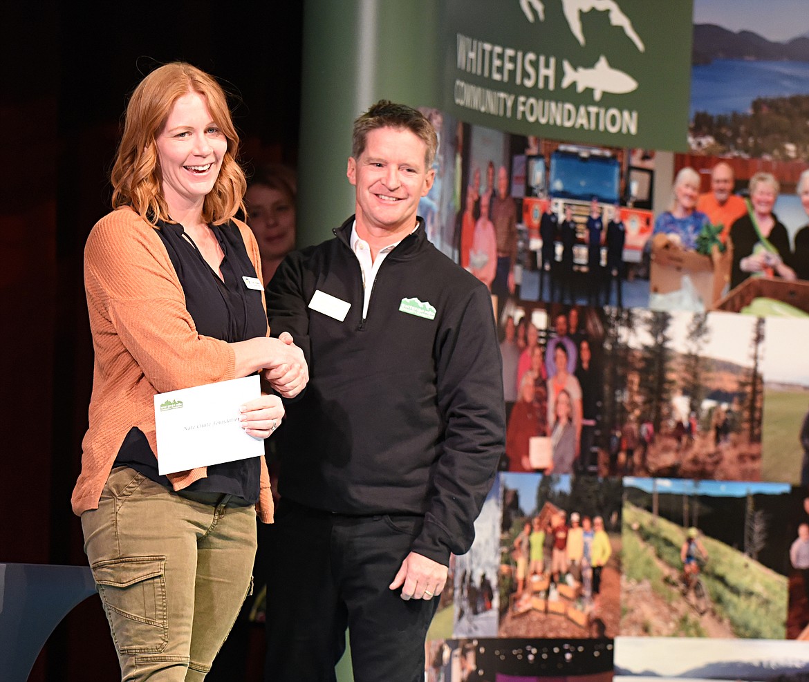 Kacy Howard, executive director of the Nate Chute Foundation, accepts a check from Doug Reed, board member for the Whitefish Community Foundation, Thursday during the Great Fish Community Challenge Awards Celebration. (Heidi Desch/Whitefish Pilot)