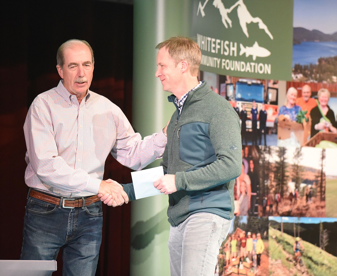 Paul Travis, executive director of the Flathead Land Trust, accepts a check from John Witt, board member for the Whitefish Community Foundation, Thursday night during the Great Fish Community Challenge Awards Celebration at the Whitefish Performing Arts Center. (Heidi Desch/Whitefish Pilot)