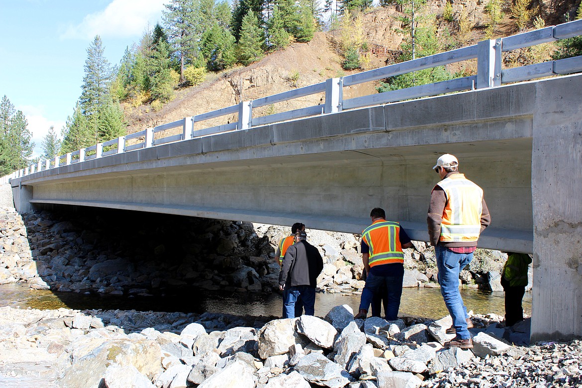 Photo by CHANSE WATSON
Officials check out the new structure from below after the ceremony. Shoshone County Public Works Director James Cason notes that this new bridge has no center support, which allows debris to pass more freely than before.