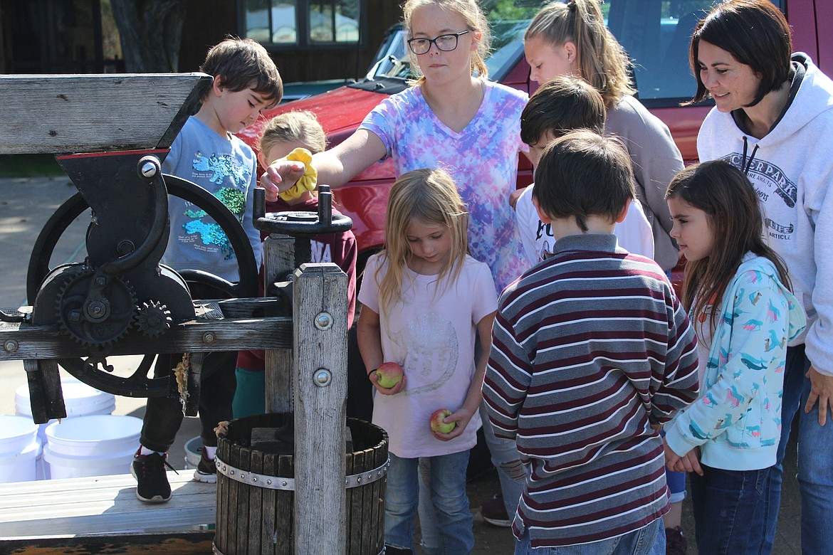 FACTURE ACADEMY students with their teacher, Shannon Doherty, working the Olson&#146;s apple press to make apple juice. (John Dowd/Clark Fork Valley Press)