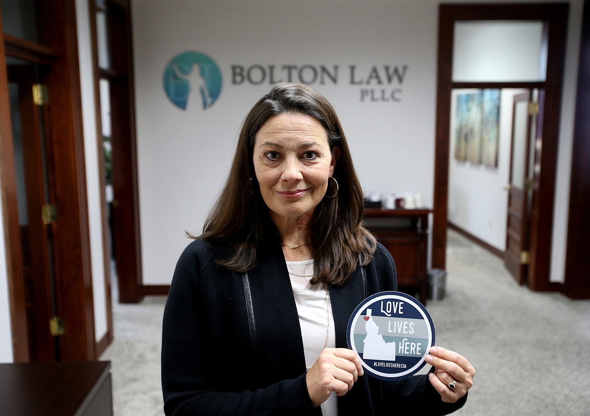 The Love Lives Here campaign asks businesses, organizations and individuals to pledge their commitment to upholding and protecting the civil and human rights of all individuals regardless of their race, creed, religion, ethnicity, gender, sexual orientation, gender identity, national origin or immigration status. Jill Bolton, owner of Bolton Law in Coeur d&#146;Alene, holds one of the stickers. (LOREN BENOIT/Press)