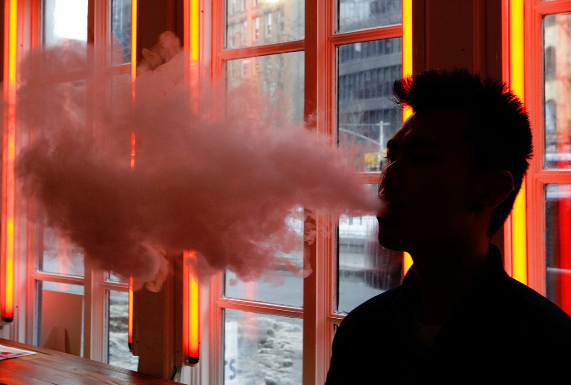 A customer exhales vapor from an e-cigarette. (AP Photo/Frank Franklin II, File)