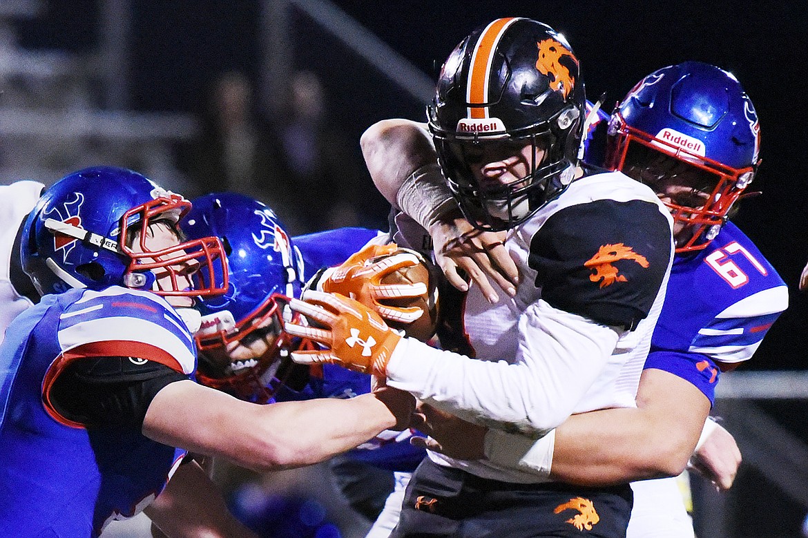 Eureka running back Chet McCully (4) is wrapped up by Bigfork defenders, from left, Levi Taylor (3), Robbie Kaiser (71) and Fletcher Postlewait (67) in the first quarter at Bigfork High School on Friday. (Casey Kreider/Daily Inter Lake)