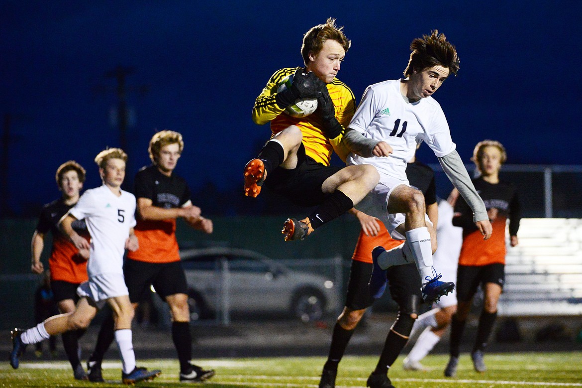 Flathead goalkeeper Hudson Magone (1) makes a leaping save as he's challenged by Glacier's Zane Elliott (11) in the second half at Legends Stadium on Tuesday. (Casey Kreider/Daily Inter Lake)