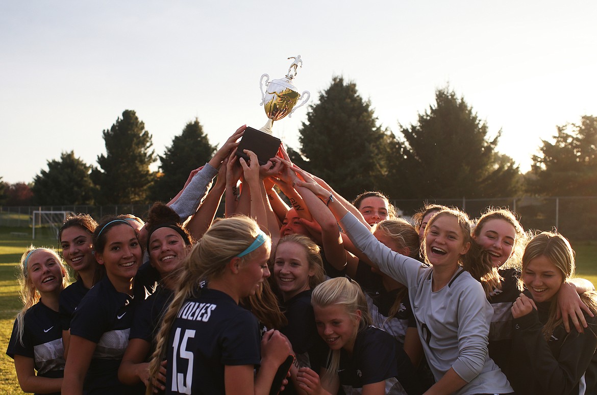 The Lake City High girls soccer team hoists the 5A Region 1 championship trophy in the air after defeating Coeur d&#146;Alene.