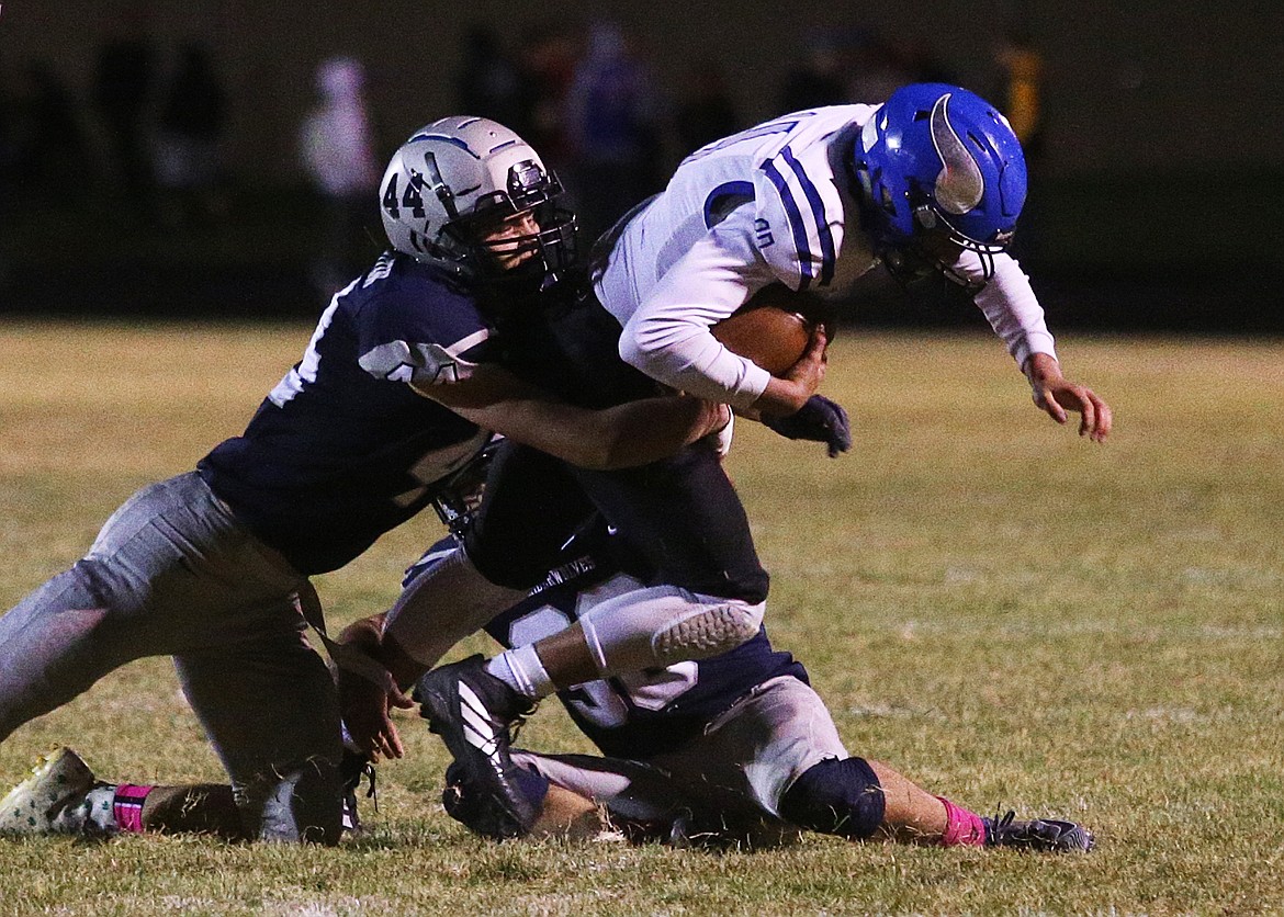 Lake City&#146;s Ian Hampton (44) and Seth Nutting tackle Coeur d&#146;Alene&#146;s Jack Dohm during Friday night&#146;s game at Lake City.