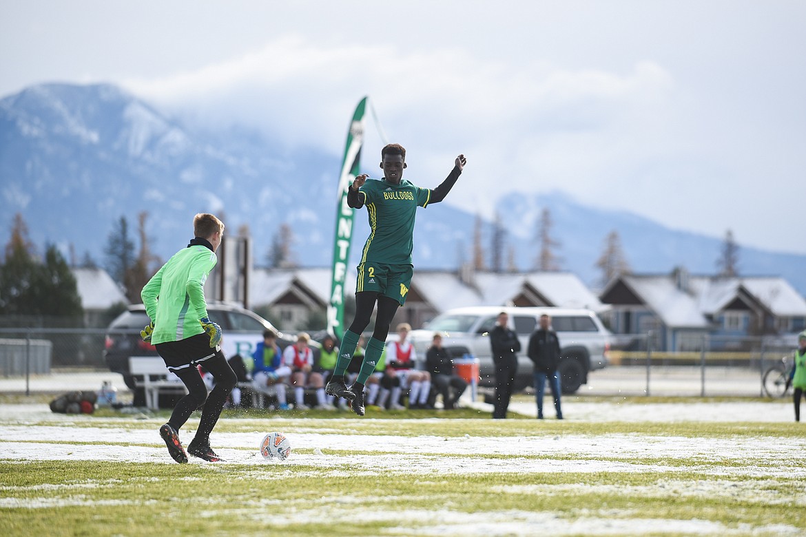 Marvin Kimera avoids a collision with the Rams' goalie during the Bulldogs' semifinal win at home on Saturday. (Daniel McKay/Whitefish Pilot)