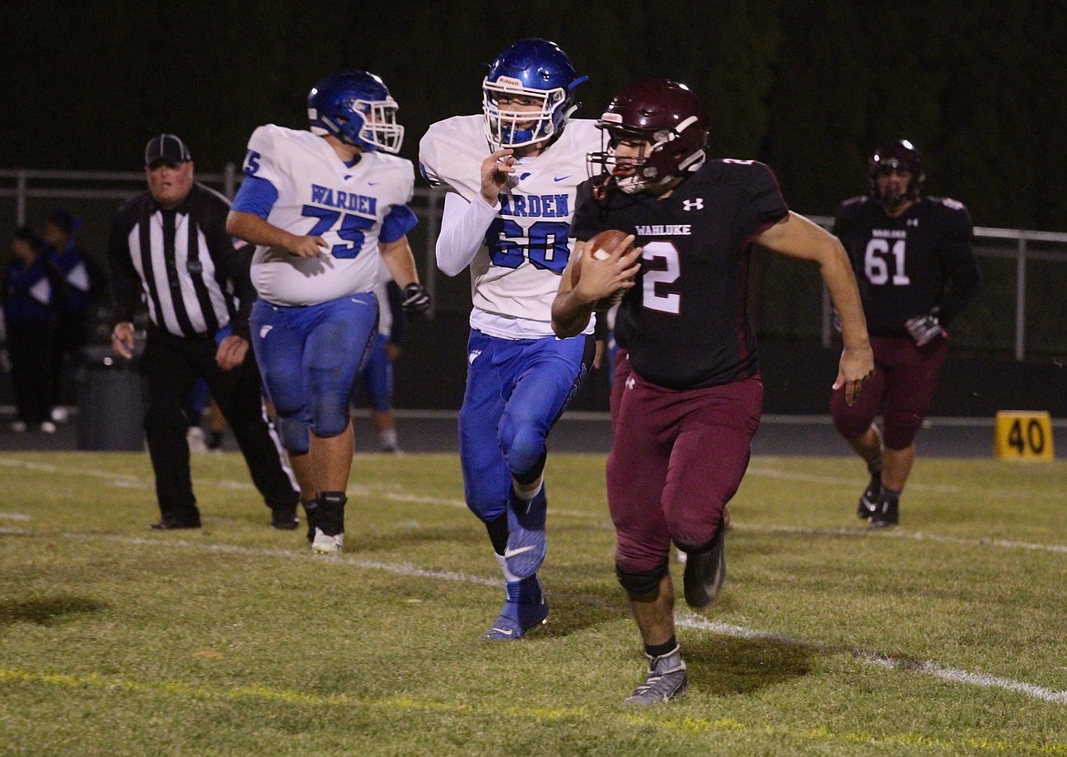 Casey McCarthy/Columbia Basin Herald Wahluke quarterback Oscar Rodriguez takes off on the ground on Friday night in Mattawa against Warden.