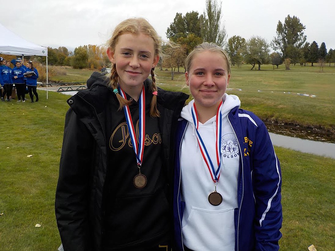 Polson Lady Pirate cross country all-conference runners Halle Heninger (left) and Karli Owens pose with the Western A Divisional Hamilton Golf Course venue in the background. Heninger placed 12th, while Owens wrapped up the last accolade with a 15th place finish. (Photo courtesy of Jenni Brown)