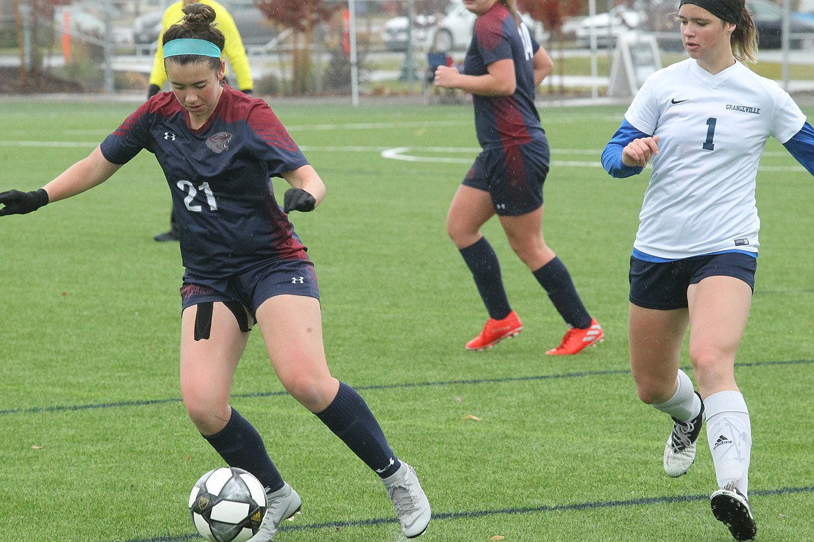 MARK NELKE/Press
Lauryn Keith (21) of Coeur d'Alene Charter Academy maneuvers away from Alleyna Edmondson of Grangeville during Saturday's 3A District 1-2 girls soccer championship game at The Fields at Real Life Ministries in Post Falls.