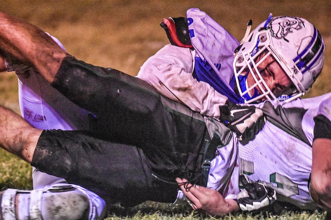 Mission Bulldog senior defensive lineman Hayden Currie sacks Flint Creek Titan quarterback Kade Cutler during third quarter action on a fourth and long conversion attempt. The key defensive play resulted in Mission taking over on downs at the 48-yard line. (Photo courtesy of Christa Umphrey, Forward Photography)