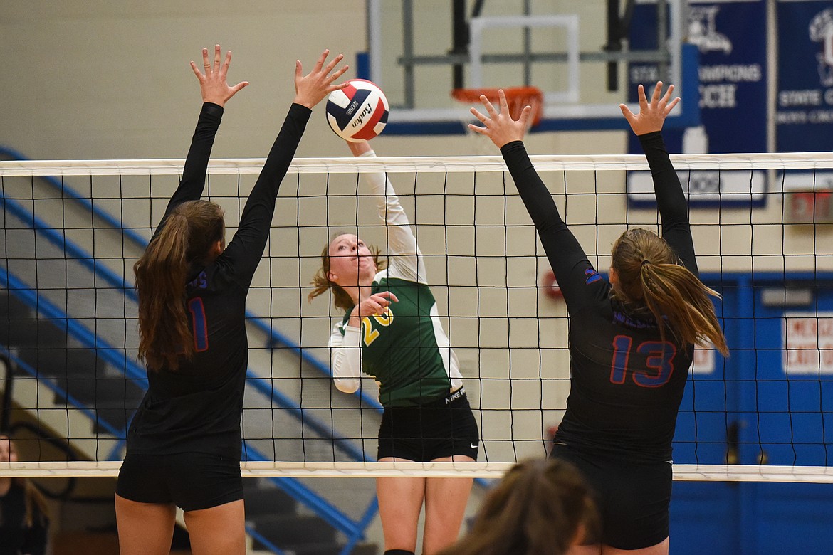 Mikenna Ells blasts the ball between two Wildkat defenders against Columbia Falls on Tuesday. (Daniel McKay/Whitefish Pilot)