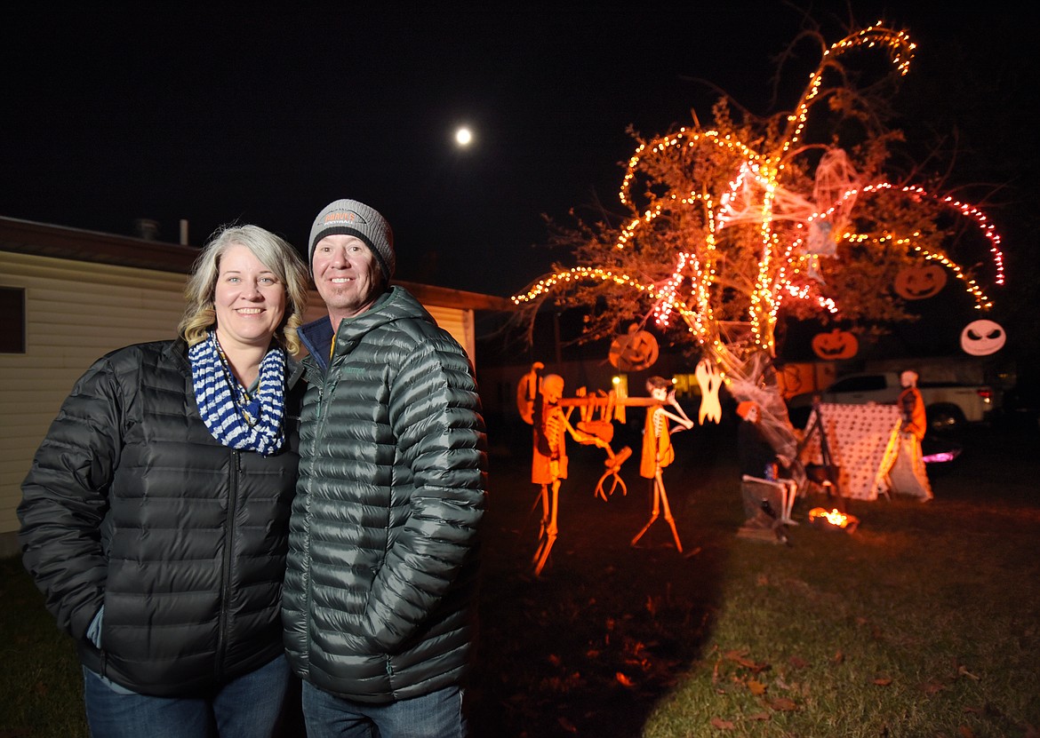 Renee and Cody stand outside their house on Friday, October 11, in Kalispell. Their yard has become a neighborhood favorite as people drive by to see what crazy thing the skeletons will be doing next.(Brenda Ahearn/Daily Inter Lake)