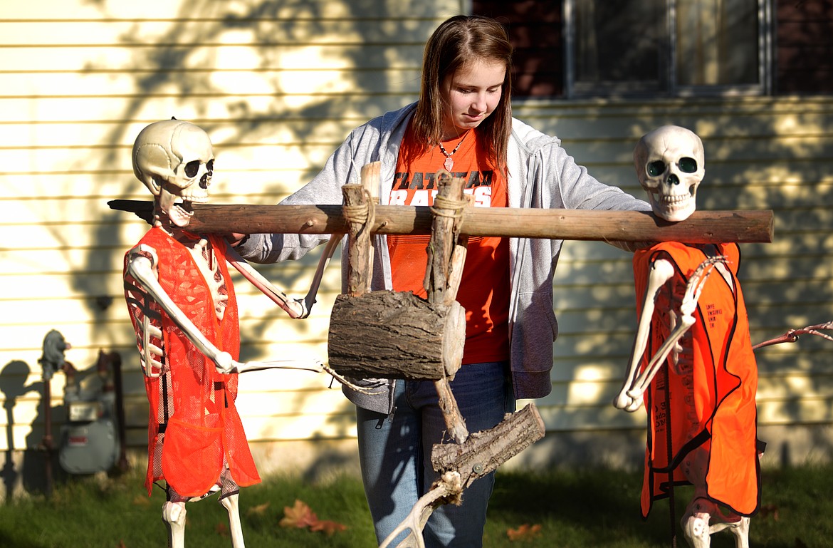 Clara Jones, 14, works on balancing a two skeletons hauling the &quot;deer&quot; to their campfire in the most recent Jones family Halloween motif.(Brenda Ahearn/Daily Inter Lake)