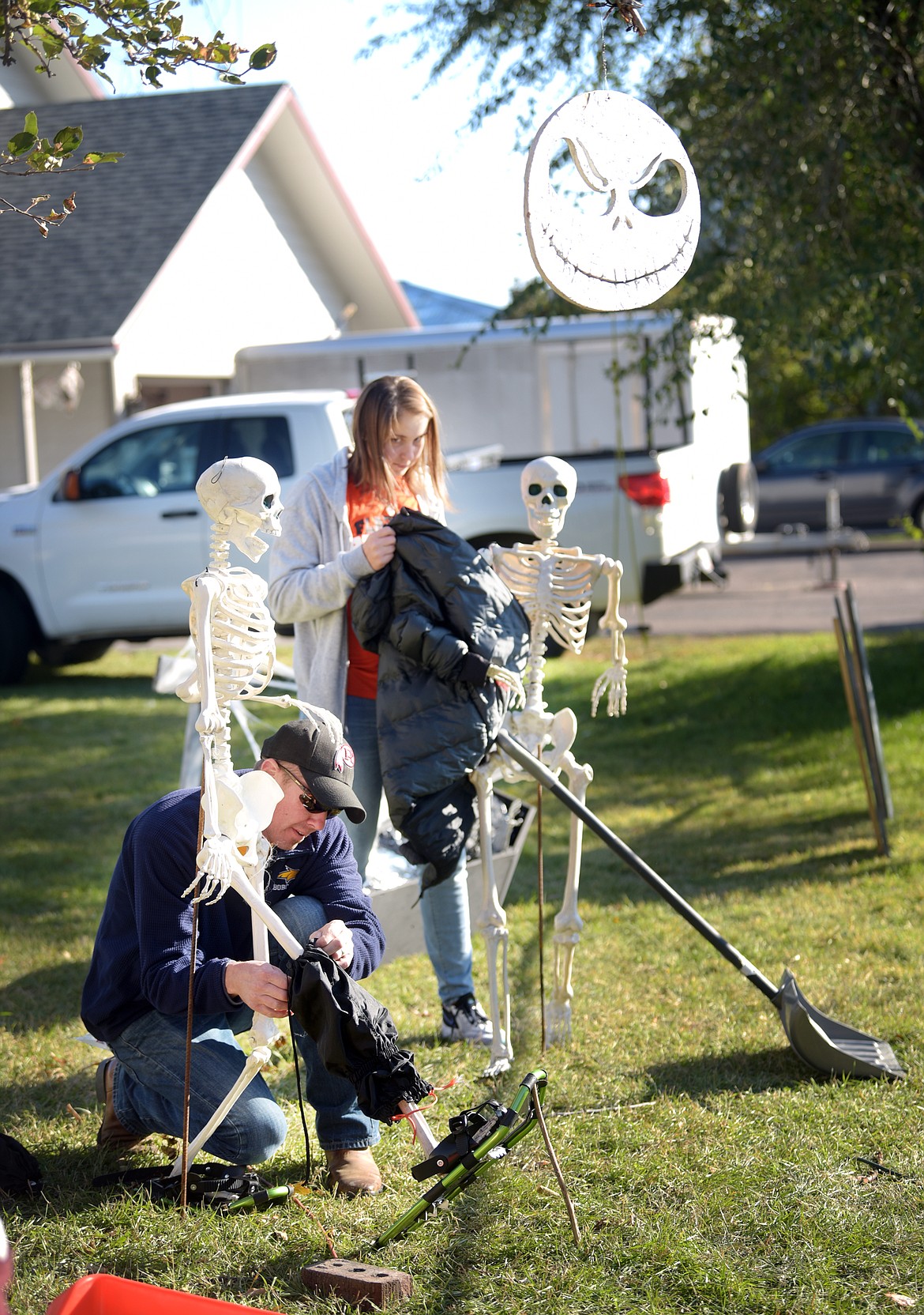 Cody Jones and his daughter, Clara, 14, begin preparing the skeletons in their yard for their new &quot;hunting&quot; theme on Friday evening, October 11, in Kalispell. Their yard, which can be seen at the southeast intersection of 11th Street West and 7th Avenue West, has become a local attraction as the family have created multiple themed scenes with their skeletons and various decorations.(Brenda Ahearn/Daily Inter Lake)