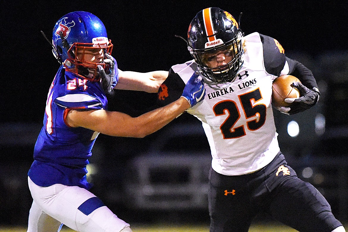 Eureka tight end Cory Chaney (25) extends a stiff-arm to Bigfork linebacker Kainin Lafontaine (24) on a reception in the first quarter at Bigfork High School on Friday. (Casey Kreider/Daily Inter Lake)