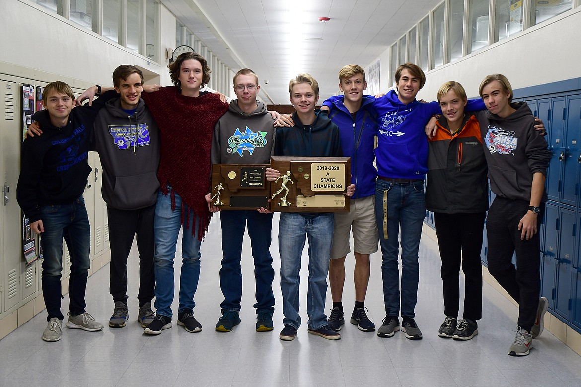 The Wildcat cross country team shows off its divisional and state championship trophies. The Cats won their second straight Class A state title in Great Falls Saturday. Pictured, from left, are Seth Umbriaco, James Petersen, Bailey Sjostrom, Joe Lamb, Coleman Wollenzien, Aidan Jarvis, James Role, TJ Jacobi and Colin Smith. (Jeremy Weber photo)