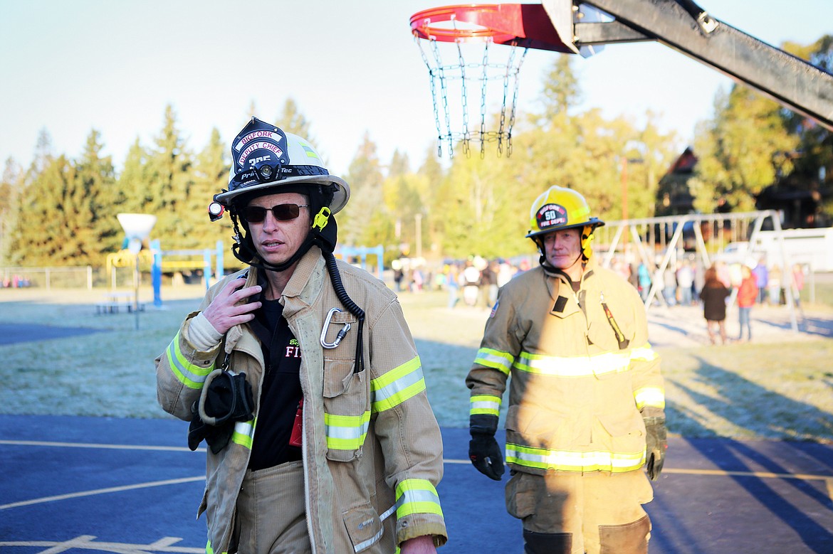 Bigfork Fire Department Deputy Fire Chief Jeremy Patton, left, and volunteer firefighter/paramedic Dave Filler check for missing students during a fire drill on Oct. 11.