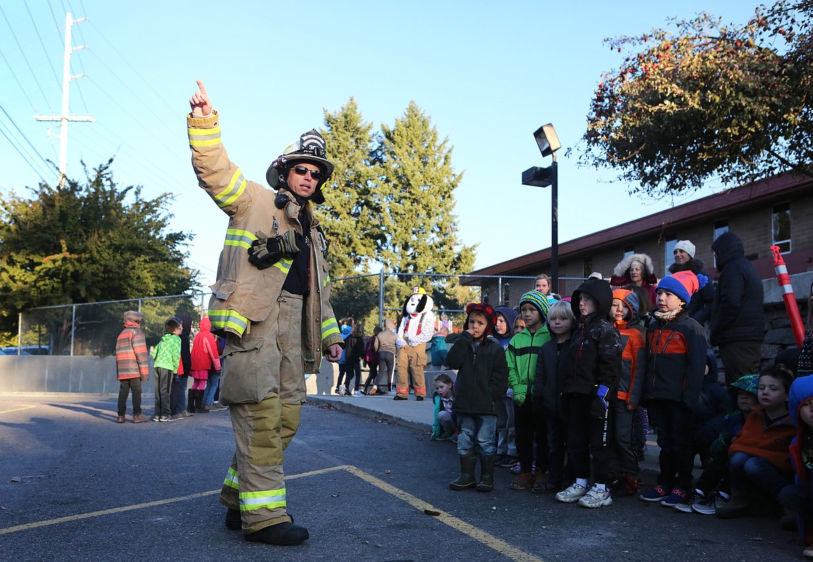 Bigfork firefighter/paramedic Jordan Lynch and volunteers, Dave Filler and Tom Pauley greet a group of elementary school children Oct. 11. The department stopped by to assist with a fire drill and to give students a tour of their ambulance and fire engine as part of their outreach for Fire Prevention Week.