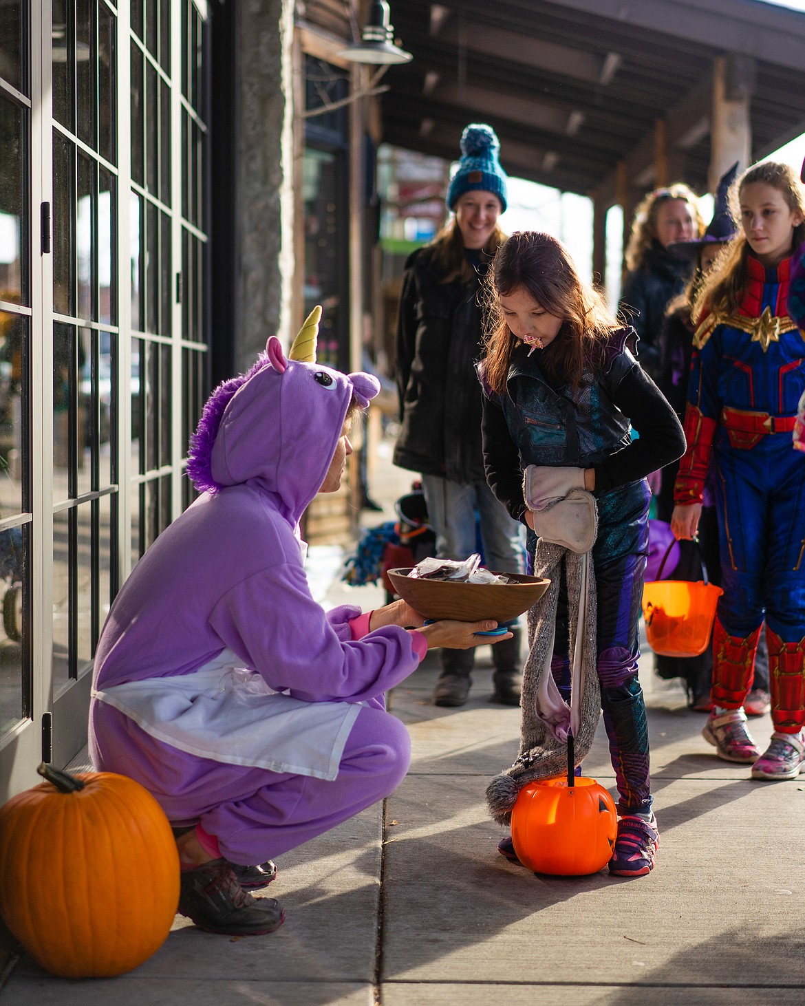 A unicorn hands out candy near Fleur Bake Shop during the Whitefish Trick or Treat downtown on Thursday. (Daniel McKay/Whitefish Pilot)