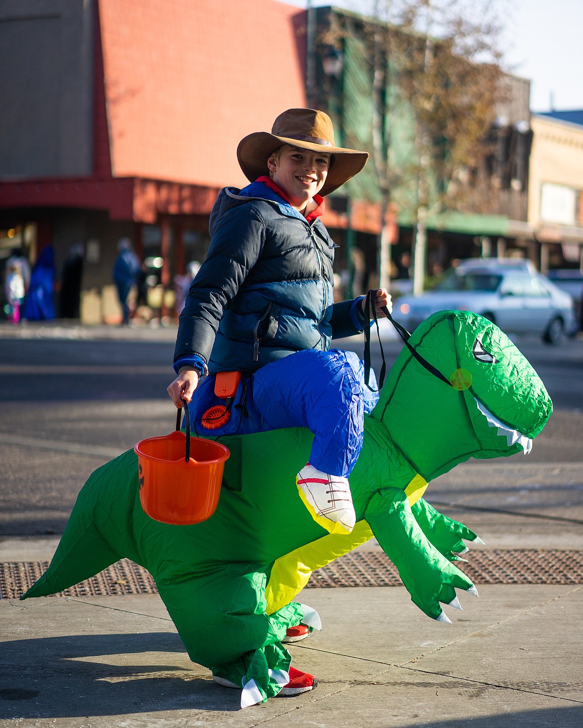 Having tamed a T-Rex, a boy begins his hunt for candy during the Whitefish Trick or Treat downtown on Thursday. (Daniel McKay/Whitefish Pilot)