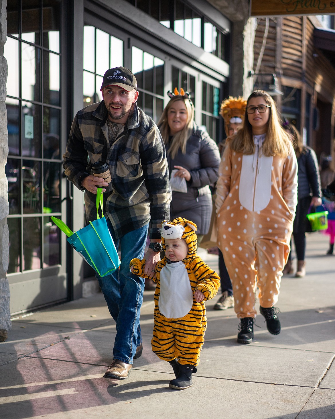 A tiger follows his handler during the Whitefish Trick or Treat downtown on Thursday. (Daniel McKay/Whitefish Pilot)